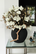 Vase noir avec magnolias blancs
