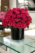 Roses rose foncé dans vase en verre noir