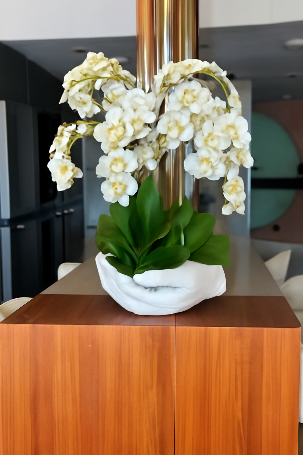 Orchidées blanches dans vase sculpture mains ouvertes blanc